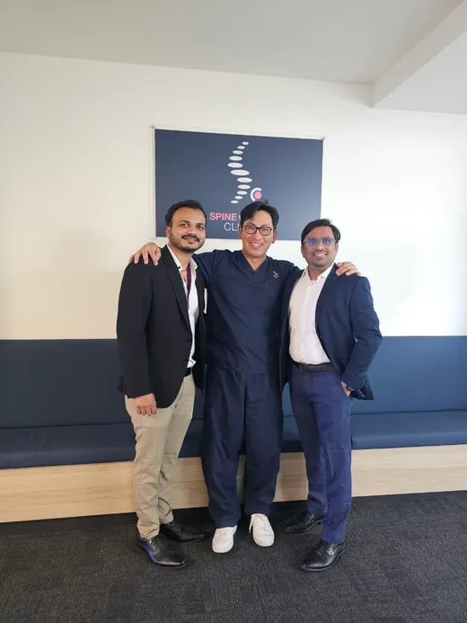 Three surgeons under the Spine Ortho Clinic sign