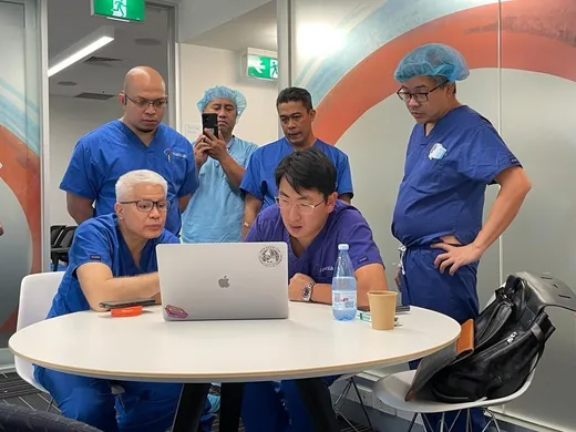 Case-review teaching session around a laptop